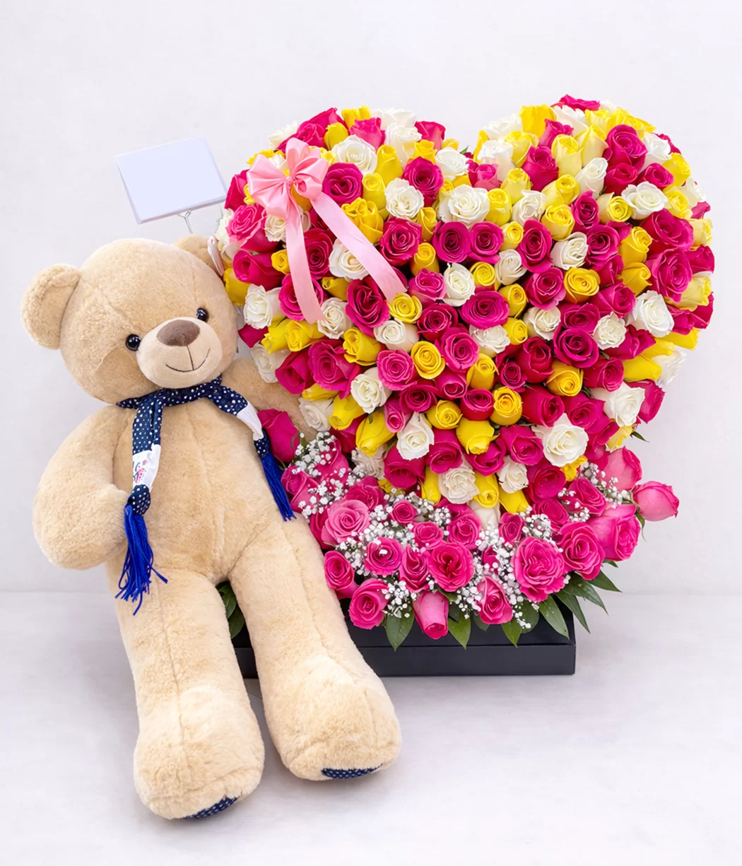 Corazón de rosas multicolor con peluche gigante, ideal como regalo romántico para sorprender en aniv